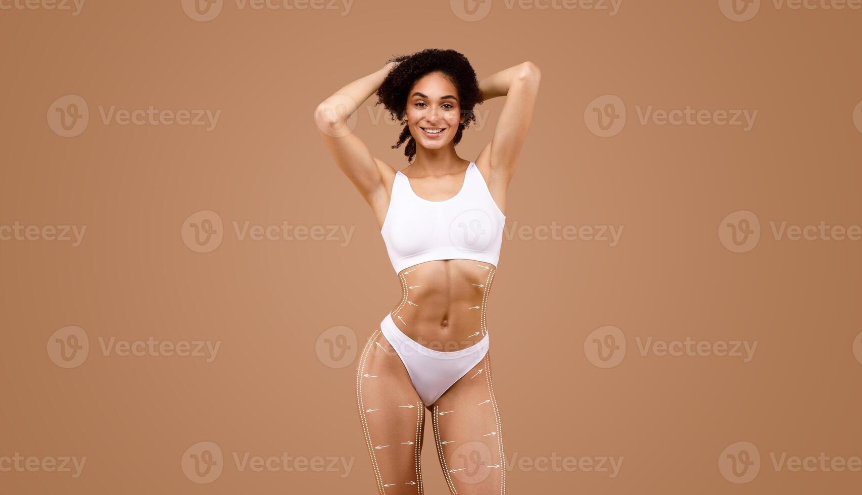 A woman stands confidently, showcasing her curves while practicing body sculpting and contouring techniques. photo
