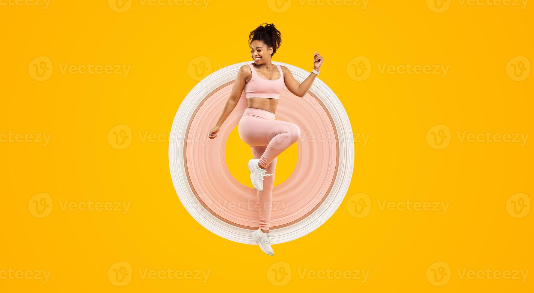 An energetic african american lady happily hopping, portraying a sense of joy and fitness, isolated against an eye-catching yellow background photo