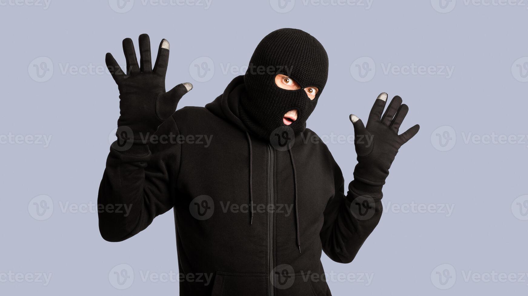 Hands Up. Masked looter being arrested by police, posing and standing isolated on white studio background photo