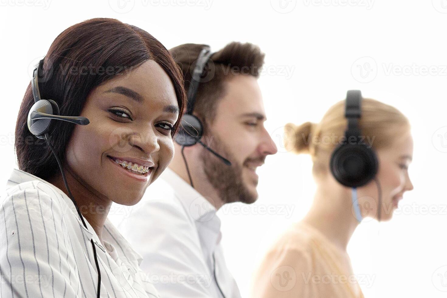 Telecommunications concept. Positive helpdesk operators selling services or goods through VoIP telephony at modern call centre. Diverse team of tech support managers talking to clients at office photo