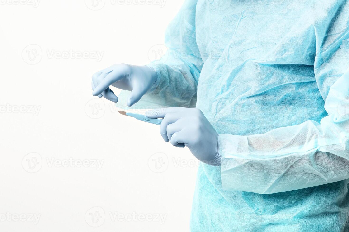 A man in a medical gown is meticulously preparing a syringe in a sterile environment, copy space photo