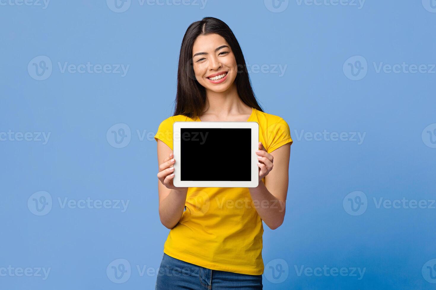 Check This Website. Smiling Korean Girl Demonstrating Digital Tablet With Black Screen Over Purple Background, Mockup Image photo