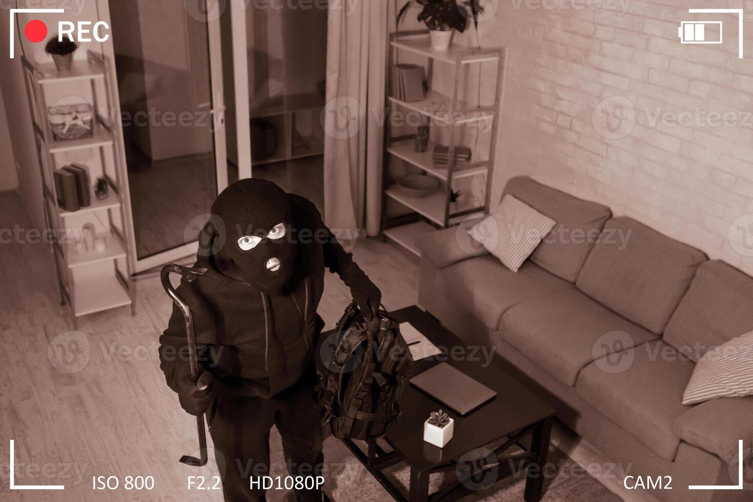 Being Caught. Robber entering house, holding crowbar and looking at CCTV camera, high angle view from above photo