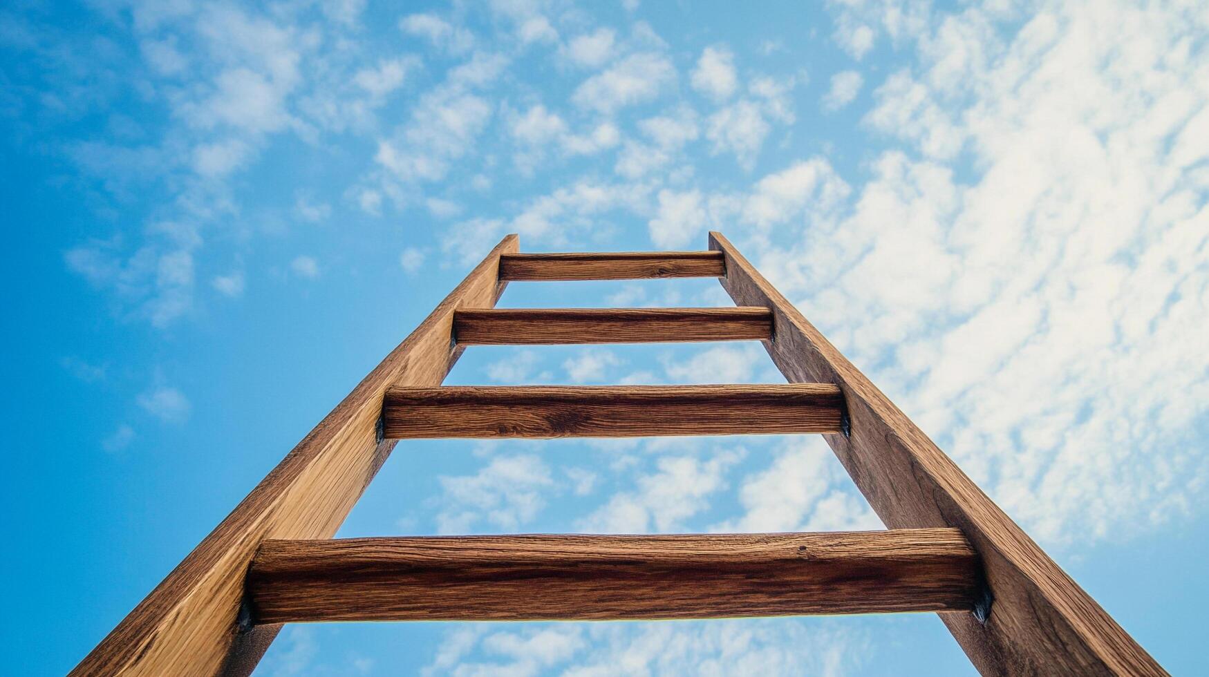 A wooden ladder pointing up against a bright blue sky filled with fluffy white clouds. A path to climb toward success and achievement. photo
