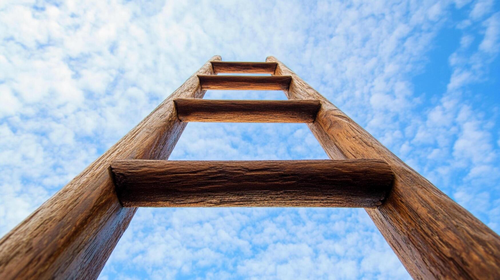 Wooden ladder against a blue sky backdrop, symbolizing ambition, growth, and upward mobility. A climb to success and self-improvement. photo