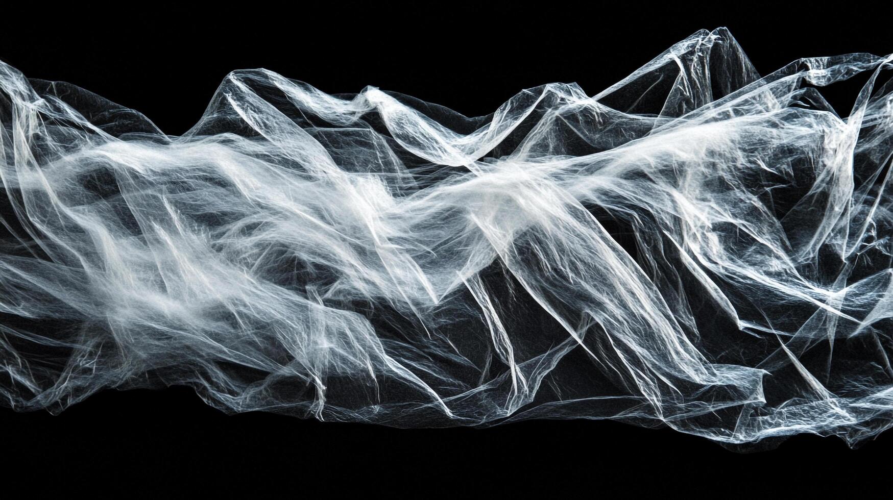Abstract image of crinkled, translucent film against a dark background, creating a ghostly, ethereal effect with light and shadow contrast. photo