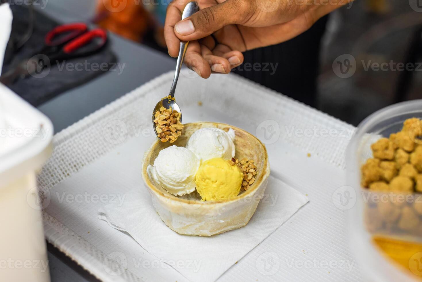 Hand hold coconut and mango ice cream in coconut shell in Jalan Alor street food market in Kuala Lumpur photo