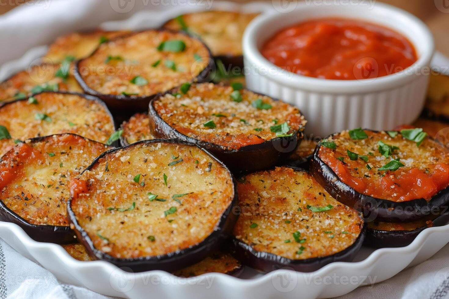 Fried eggplant slices served with tomato sauce and garnished with parsley photo