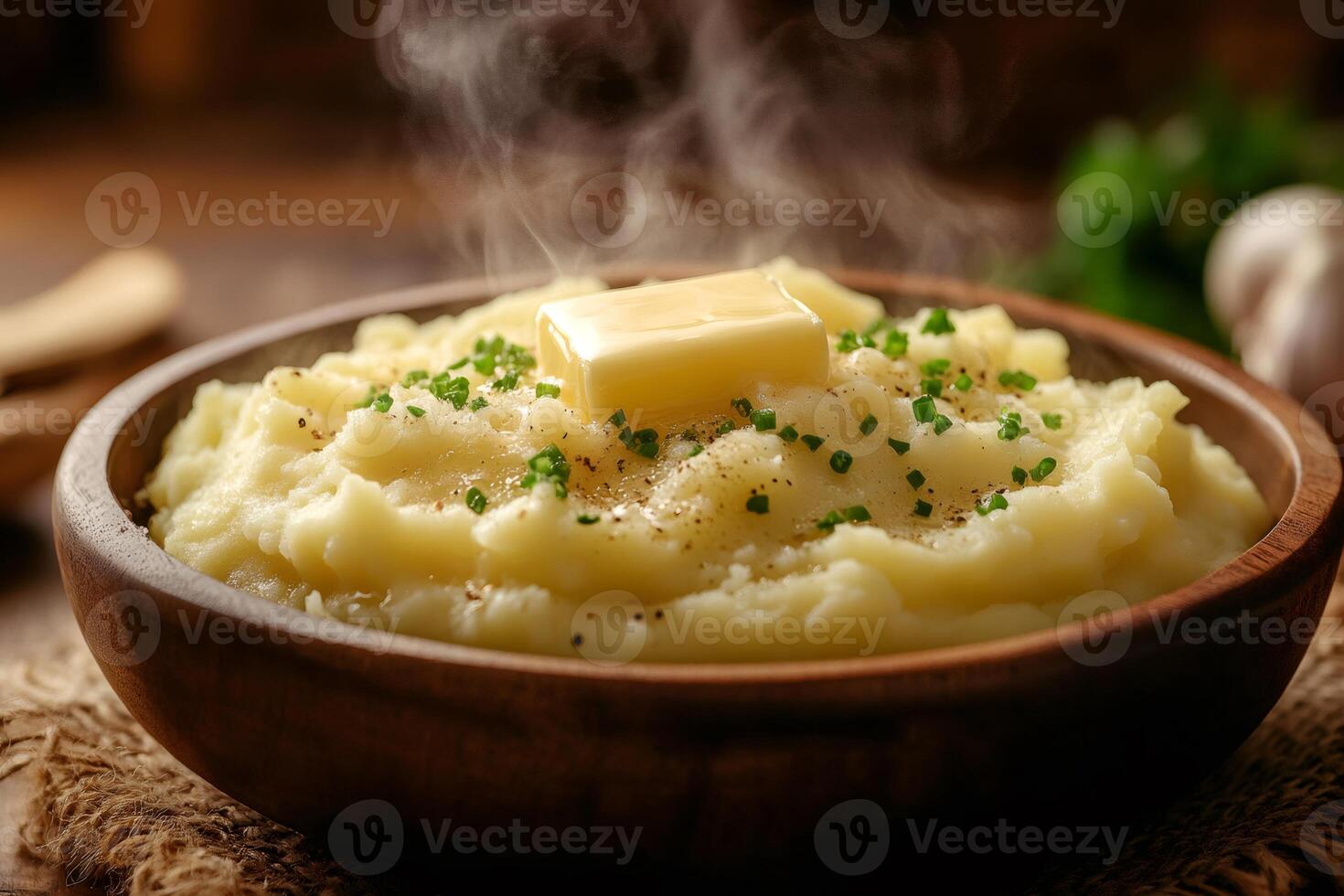 Steaming mashed potatoes with melting butter and chives in wooden bowl photo