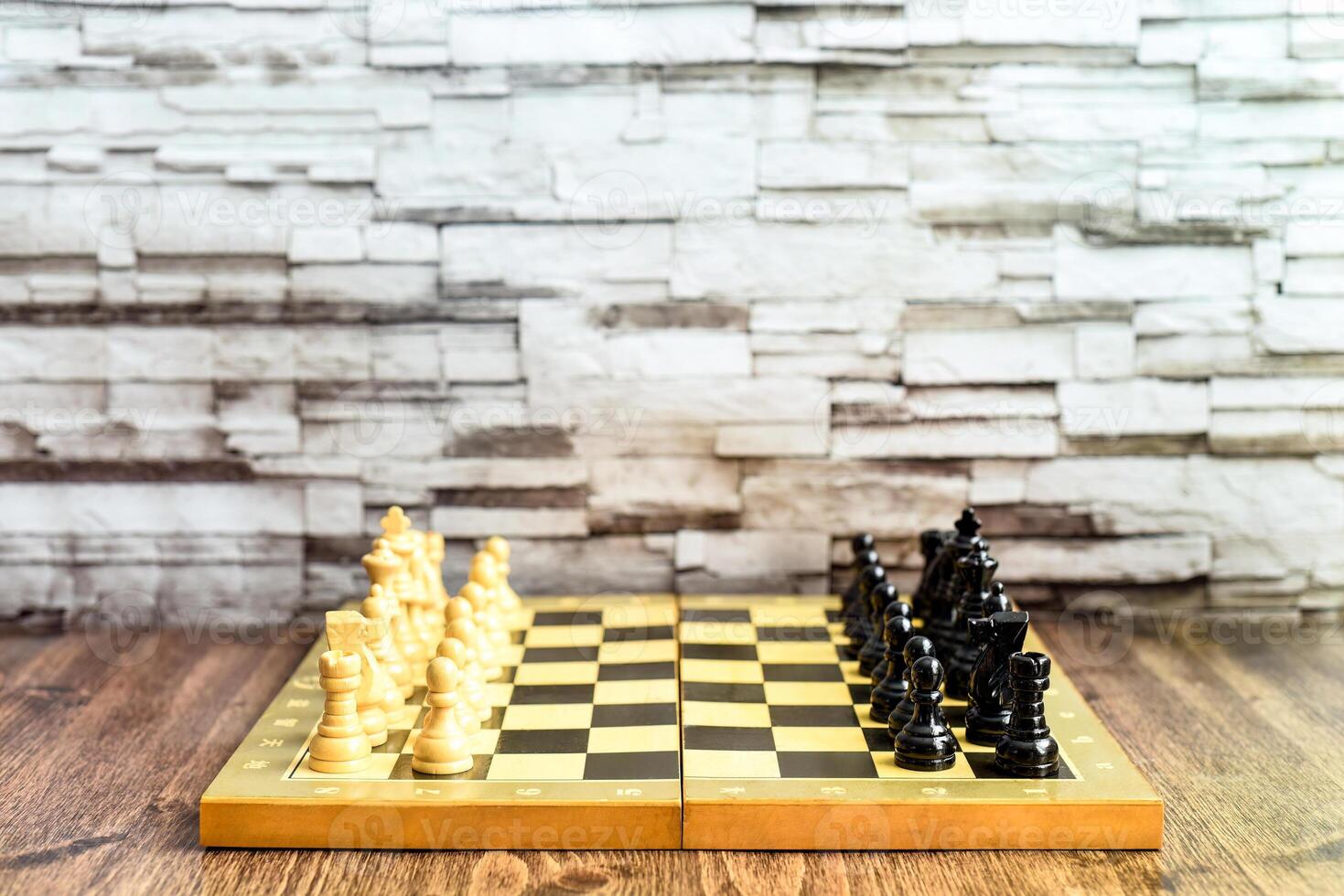 Chess pieces on chess board on wooden table. Blurred background with copy space photo
