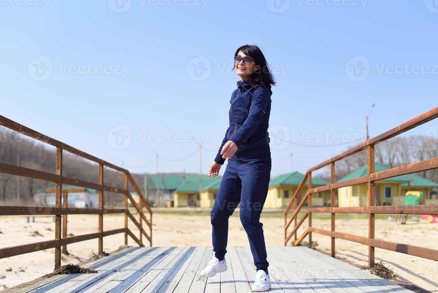 Cheerful 45 y.o. Russian woman running towards the camera and laughing photo