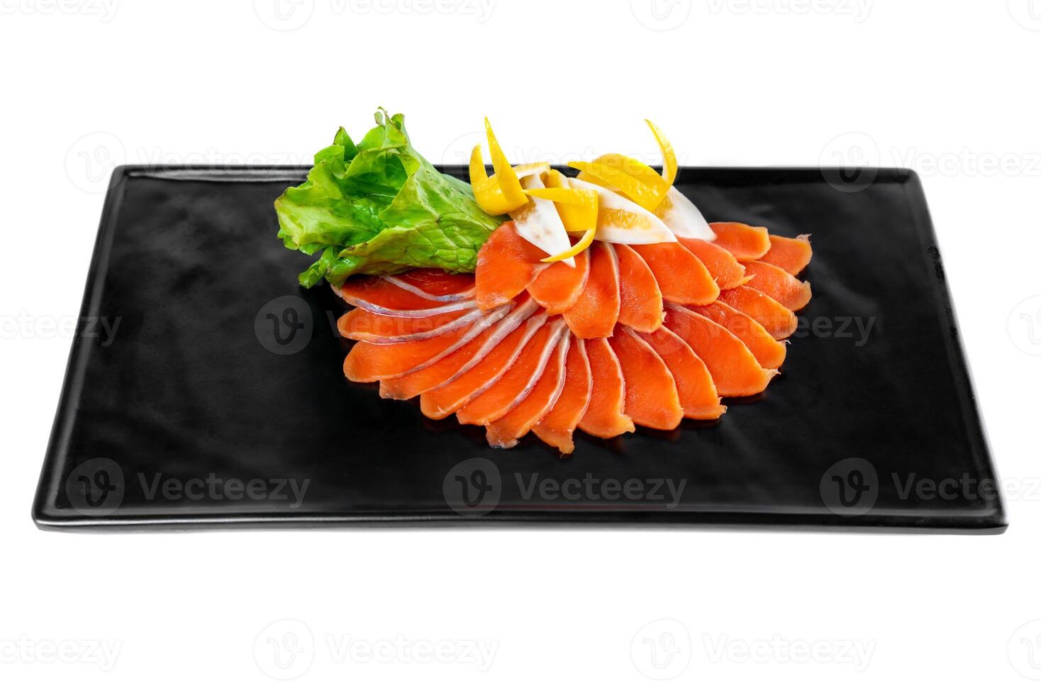 slicing appetizer of red fish slices on a black plate on a white background top view photo