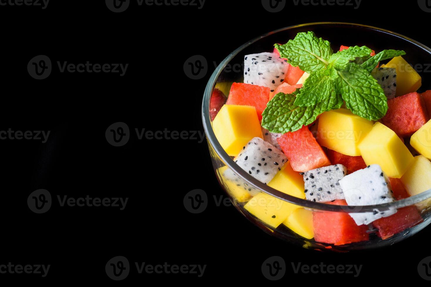 Fruit salad made of fruits isolated on black background side view photo