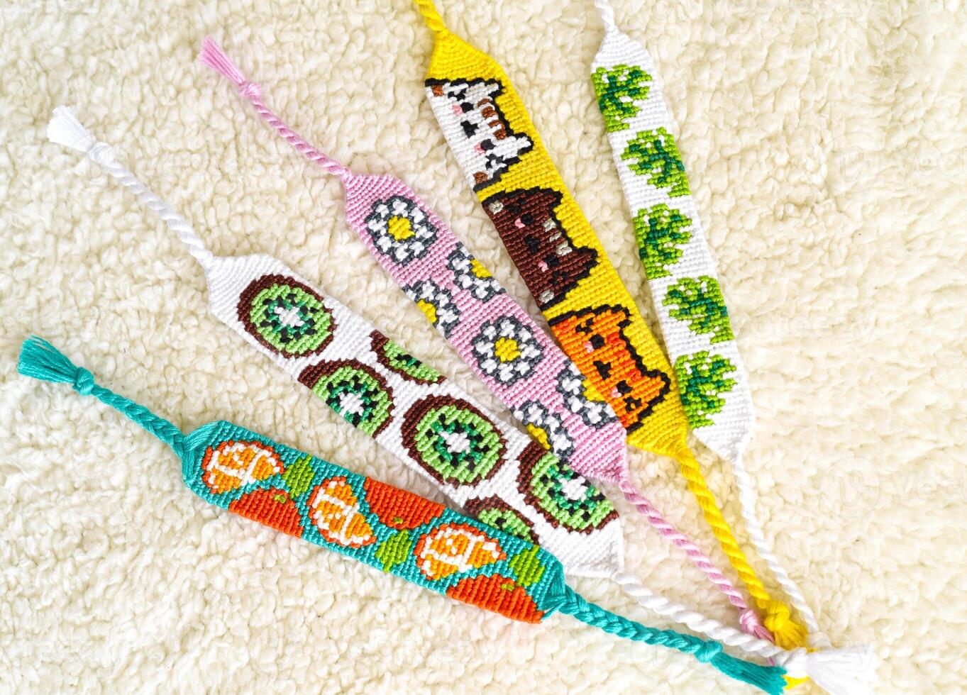 DIY friendship bracelets handmade of embroidery bright thread with knots isolated on white background. Alpha patterns photo