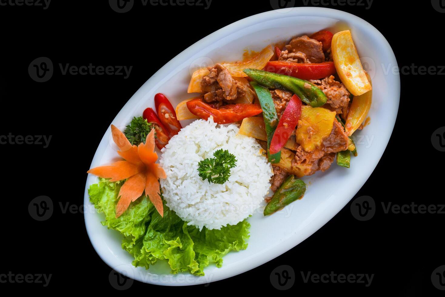 Stewed pork with vegetables and rice isolated on black background top view photo