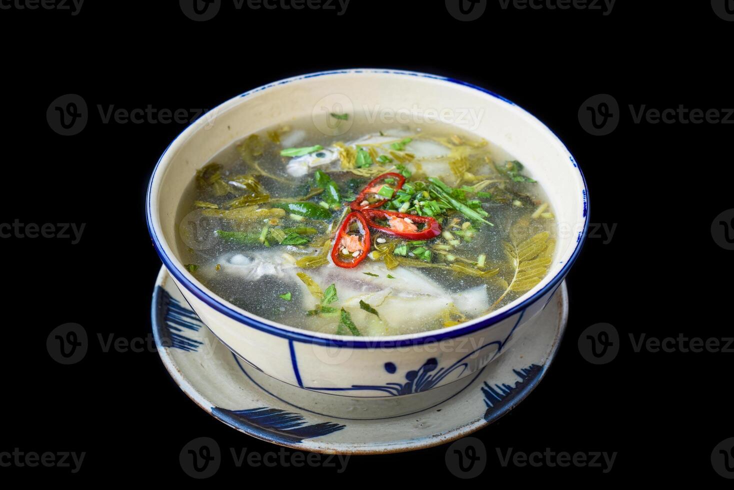 Canh Chua Ca or Vietnamese Sour Catfish Soup isolated on a black background photo