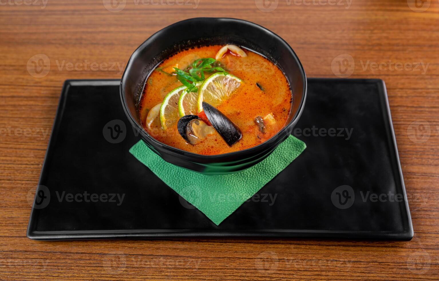 Soup tom yum with seashells and mussels on wooden table photo