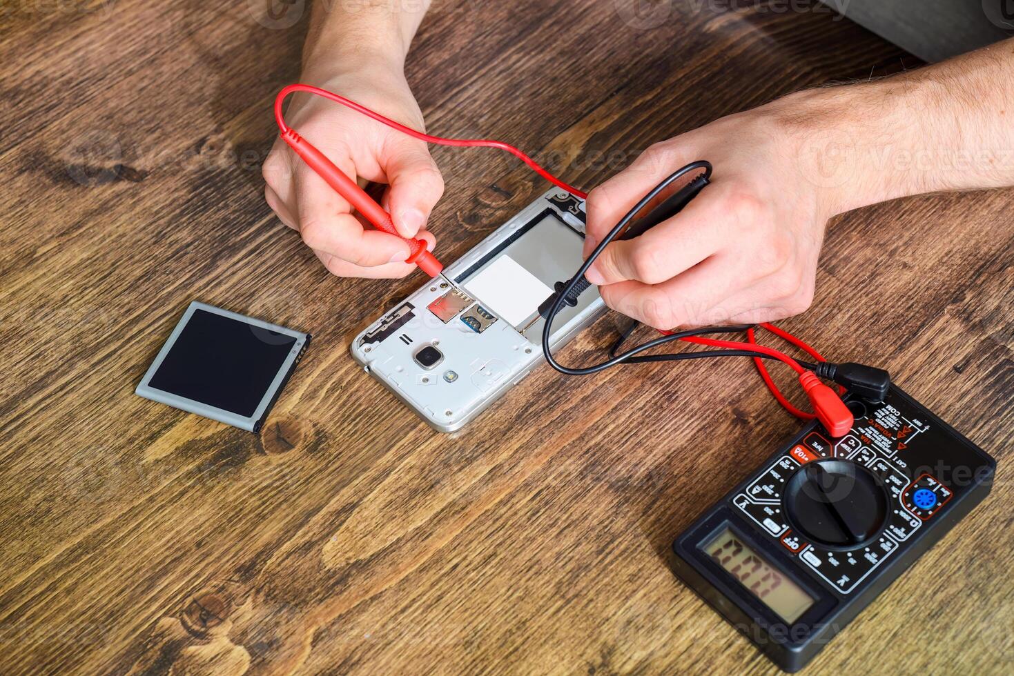 Phone repair concept. Checking with a multimeter photo