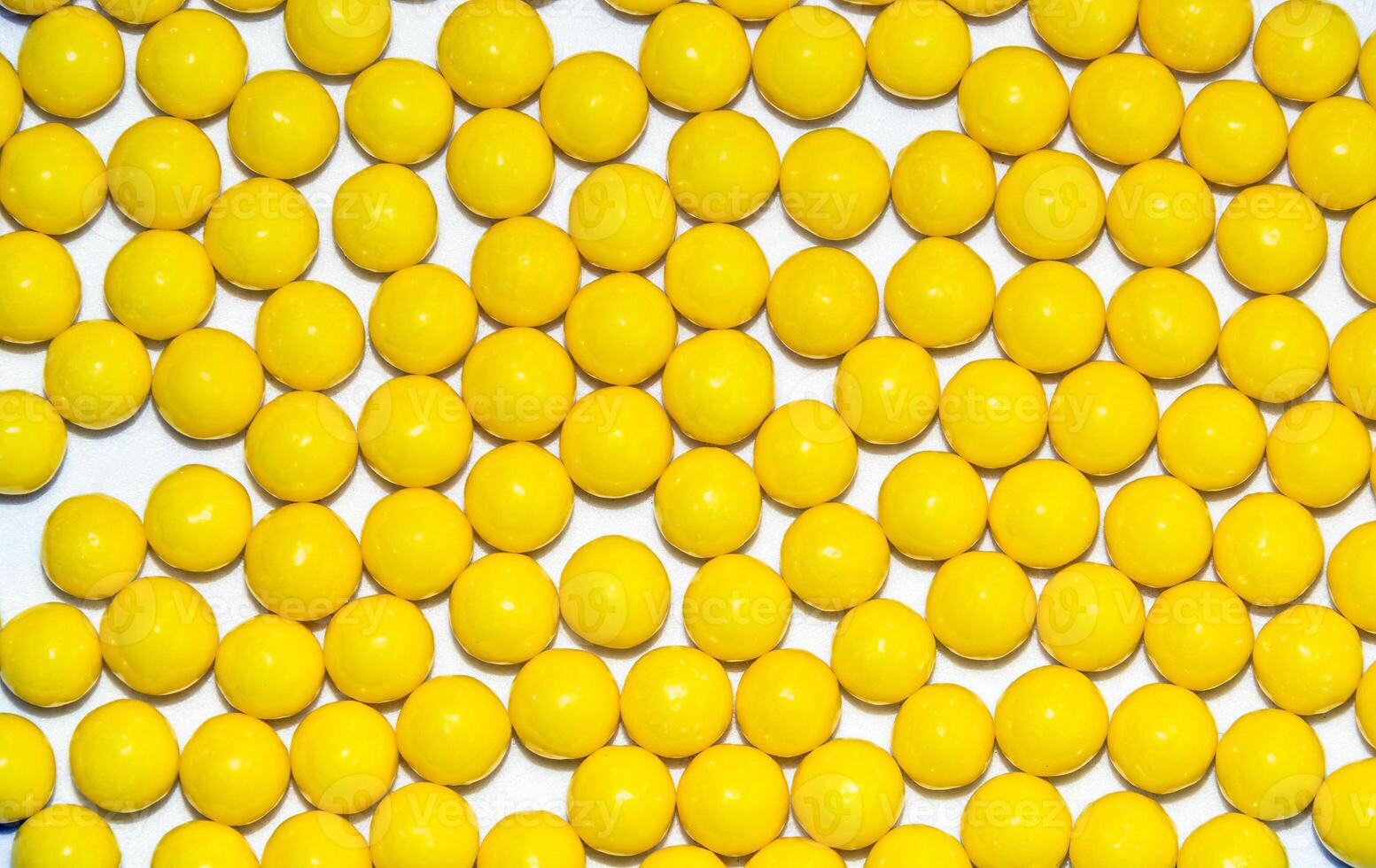 Many yellow round dragees of ascorbic acid vitamin C isolated on a white background photo