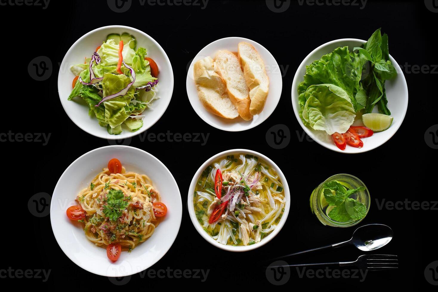 Lunch set made of chicken soup, salad, banh mi pasta carbonara, lemonade on black background photo