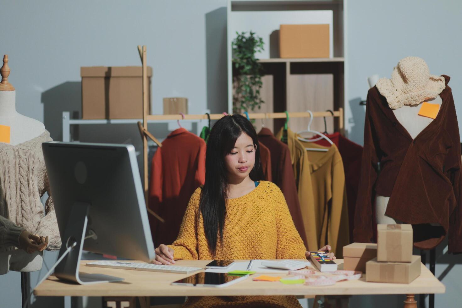 A woman sitting at a desk with a computer and a laptop photo