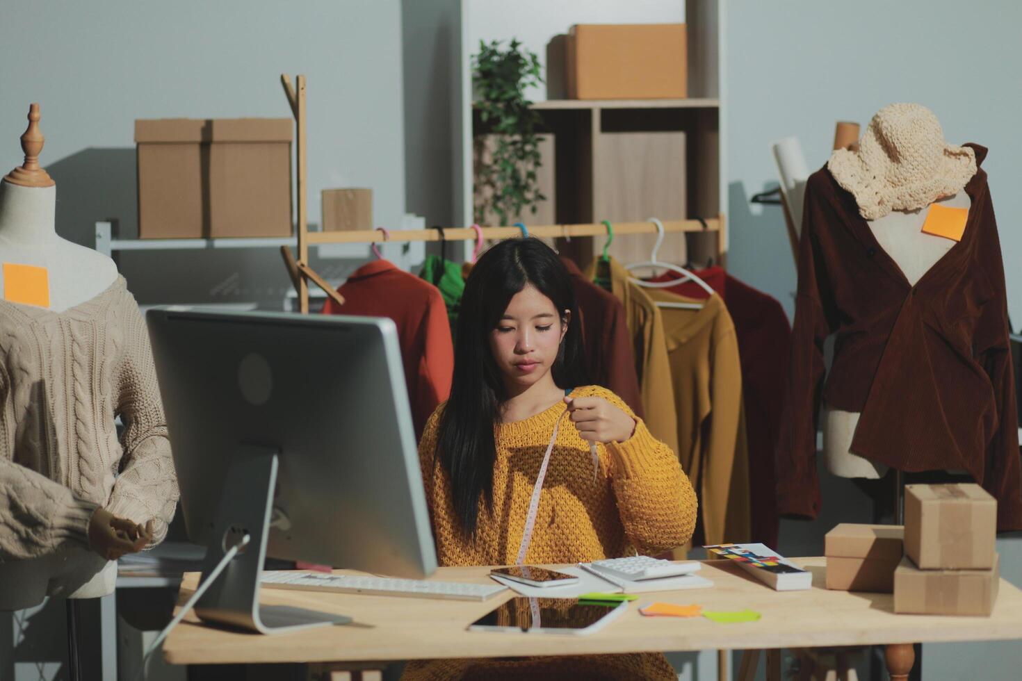 A woman sitting at a desk with a computer and a laptop photo