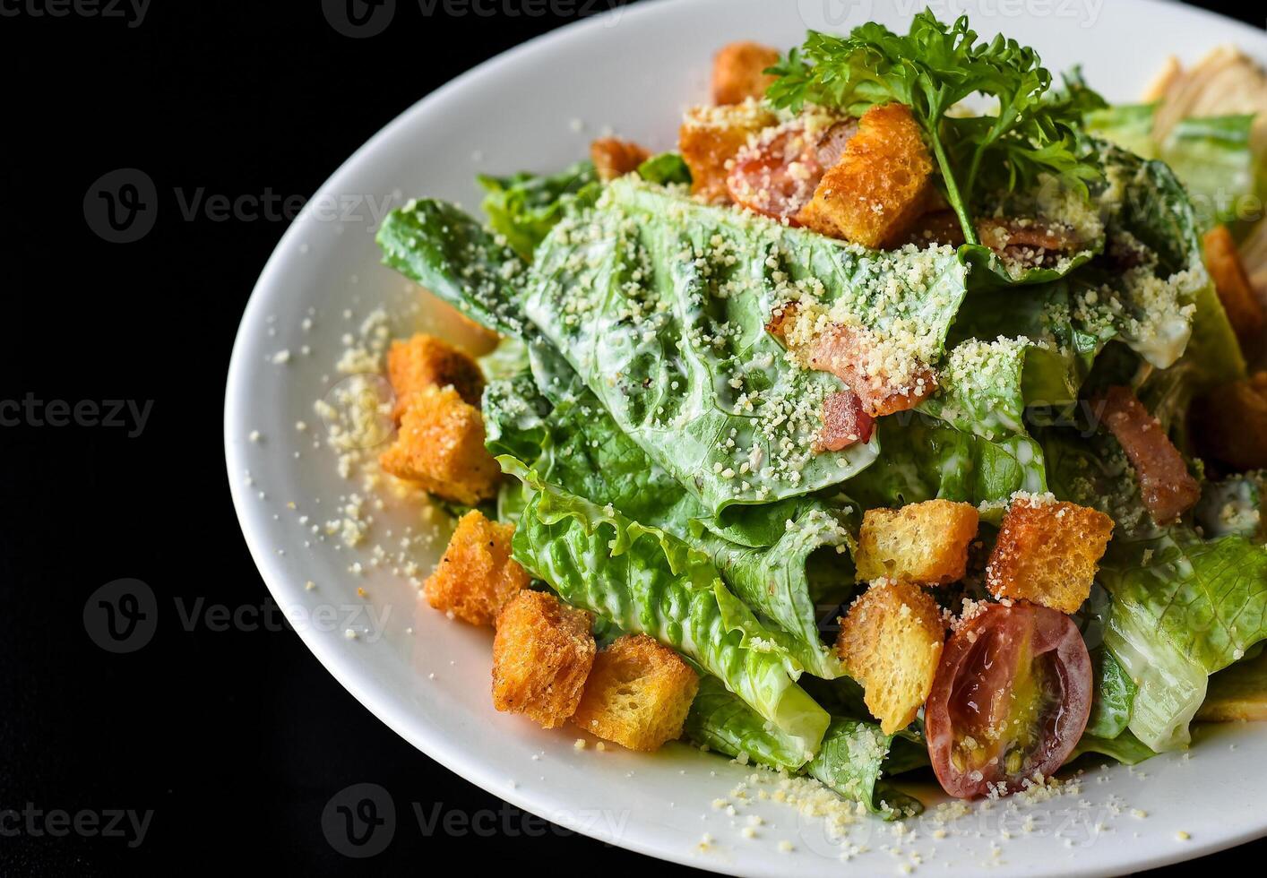 Caesar salad served in Vietnamese style on a black background side view photo