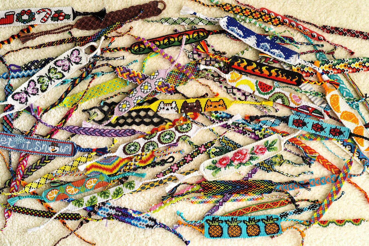 Many Woven DIY friendship bracelets handmade of embroidery floss with knots, alpha patterns photo