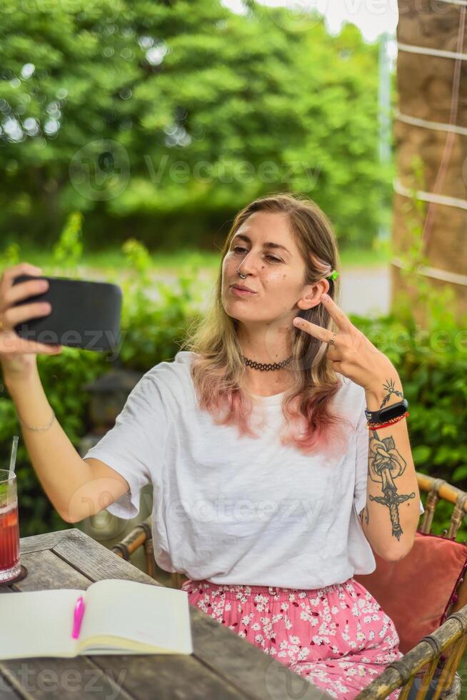 Cute woman taking a photo selfie in summer garden