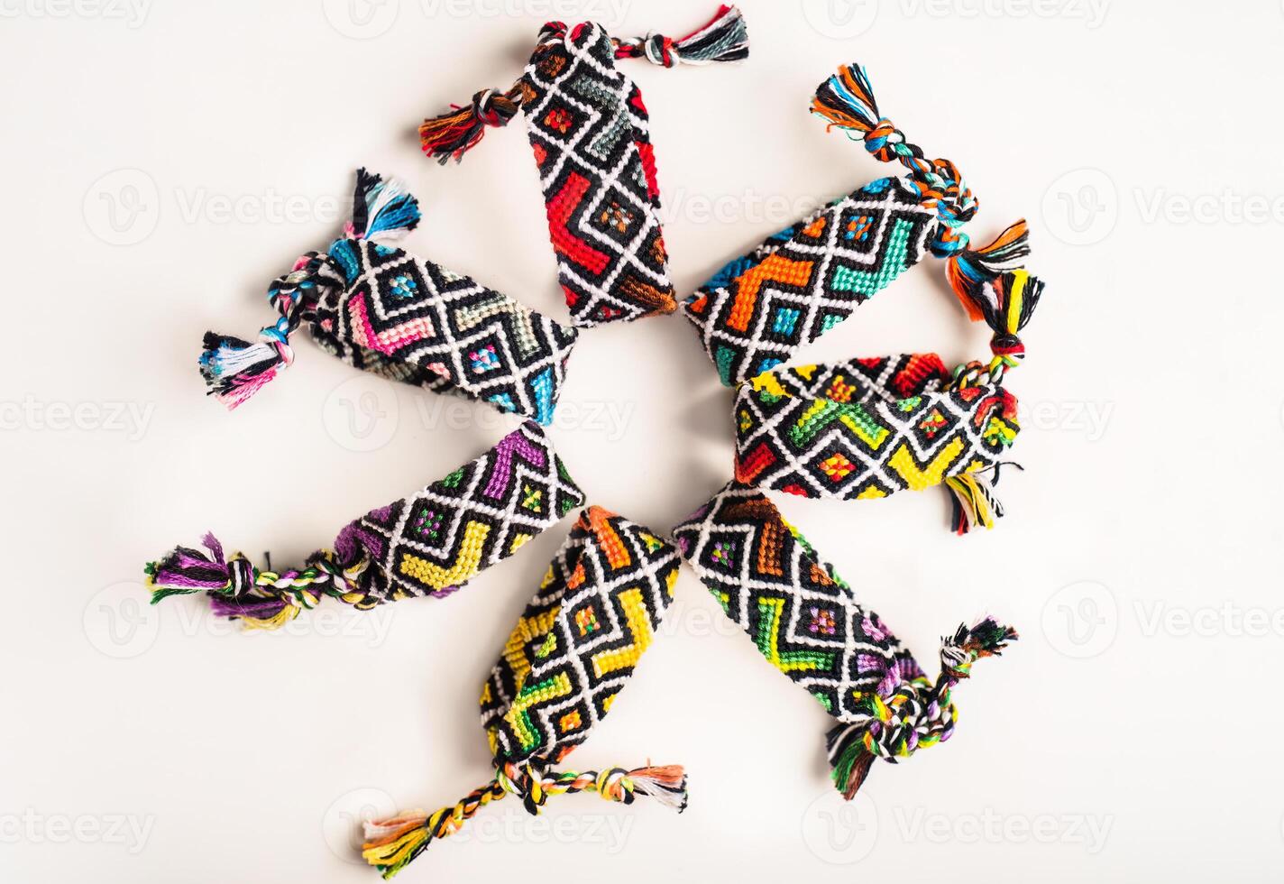 Multicolored woven DIY friendship bracelets handmade of embroidery thread with knots isolated on white background photo