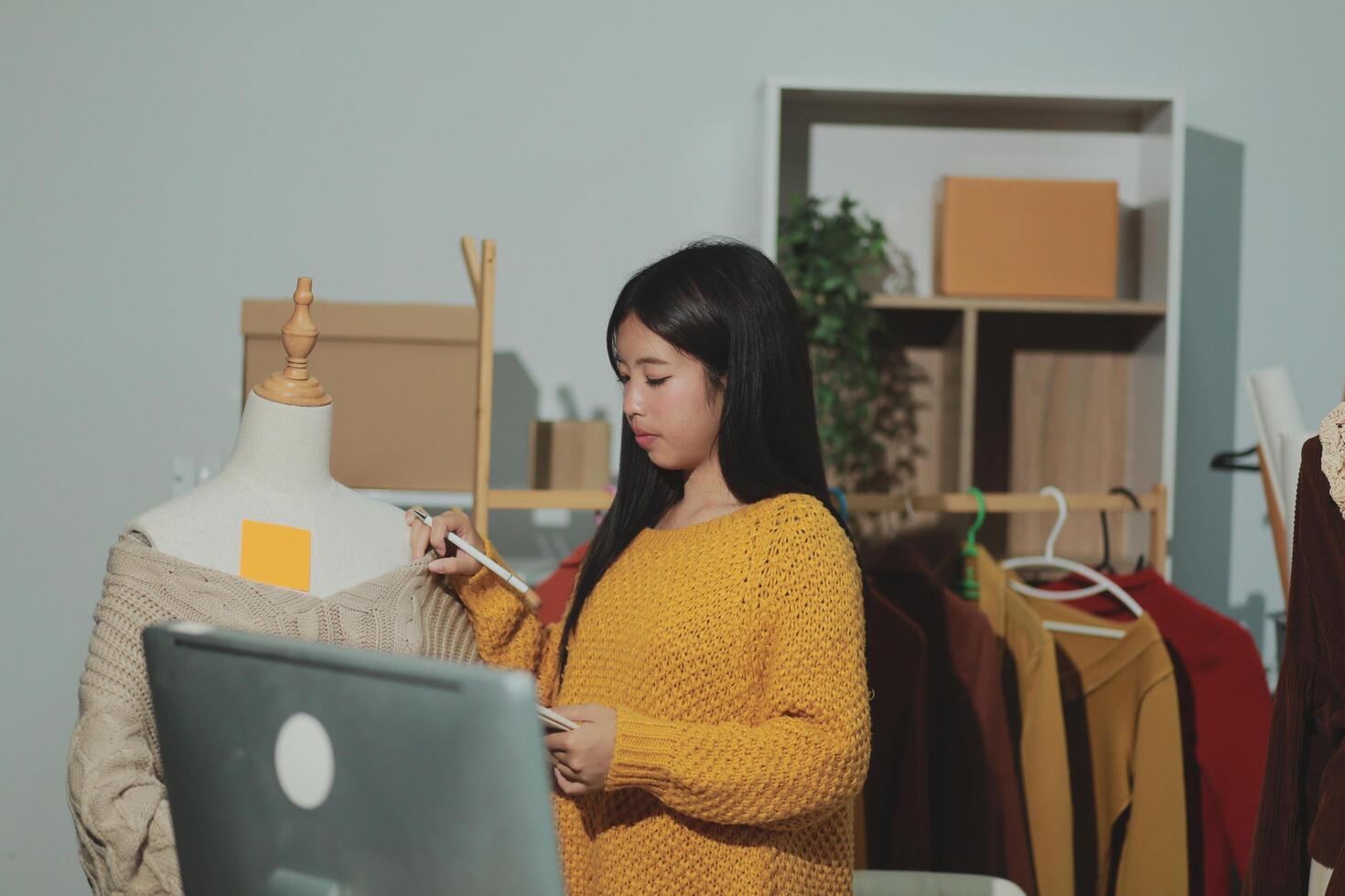 A woman is looking at a computer screen while wearing a yellow sweater photo