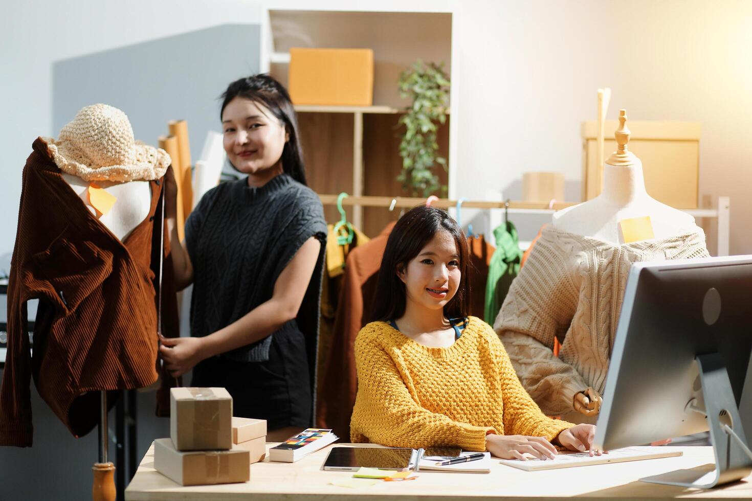 Two women working at a computer in a clothing store photo