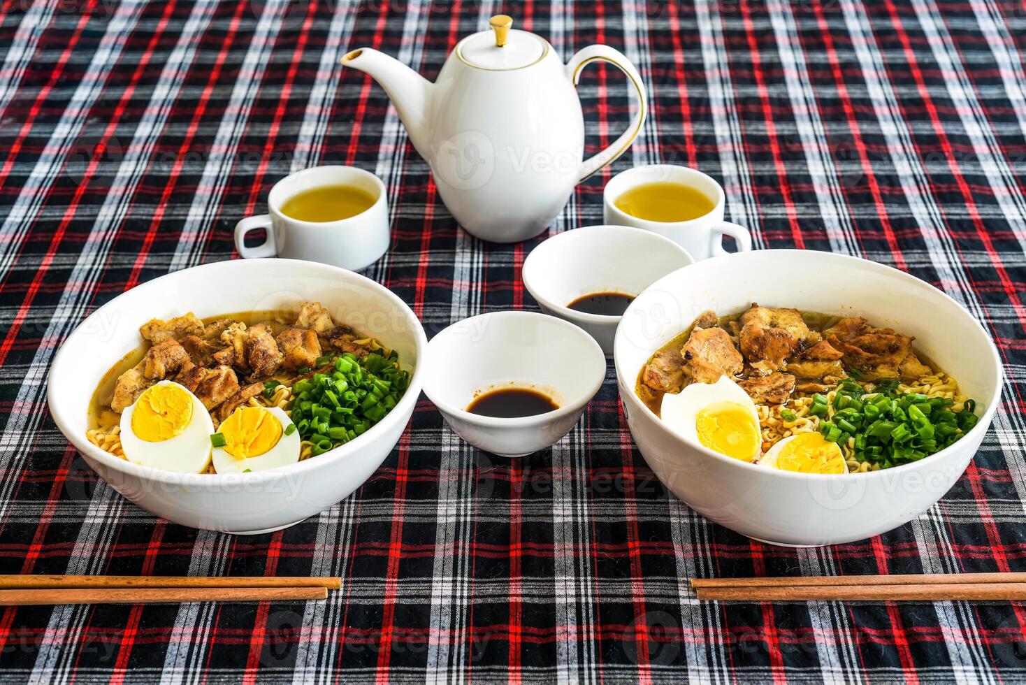 Japanese ramen with chicken and soy sauce on the table with teapot and green tea photo