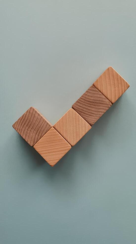 Check mark on wooden blocks on light blue background photo