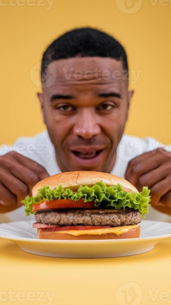 A man is holding a hamburger in front of him photo