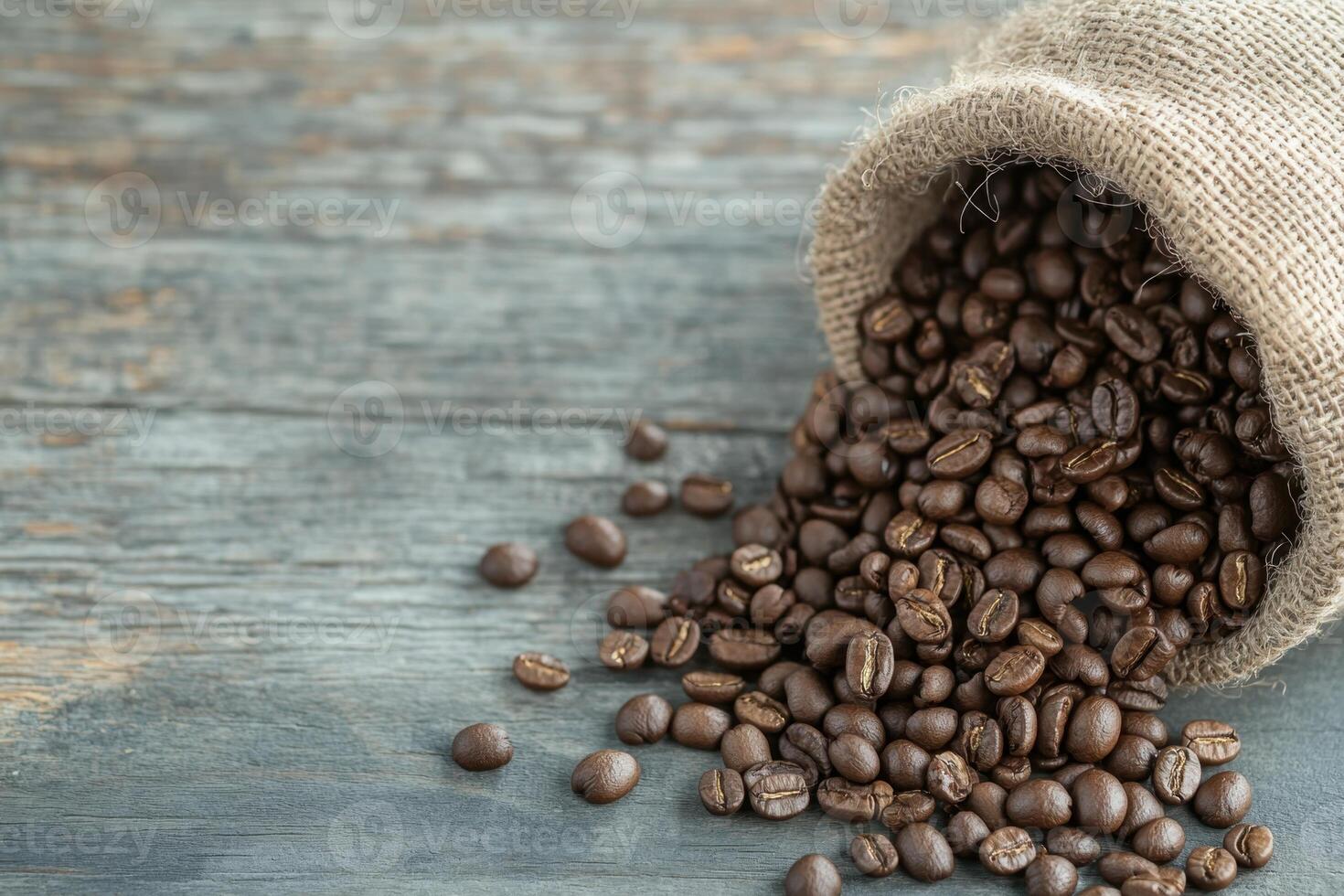 Roasted coffee beans spilling from a burlap sack onto a rustic wooden table. Aromatic delight photo