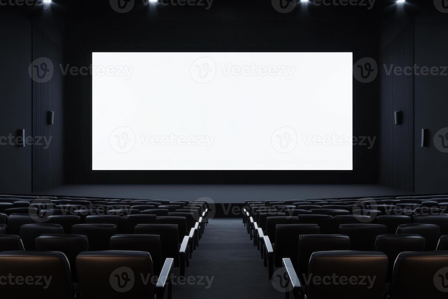 An empty, dark movie theater with rows of seats facing a bright white screen, awaiting viewers photo