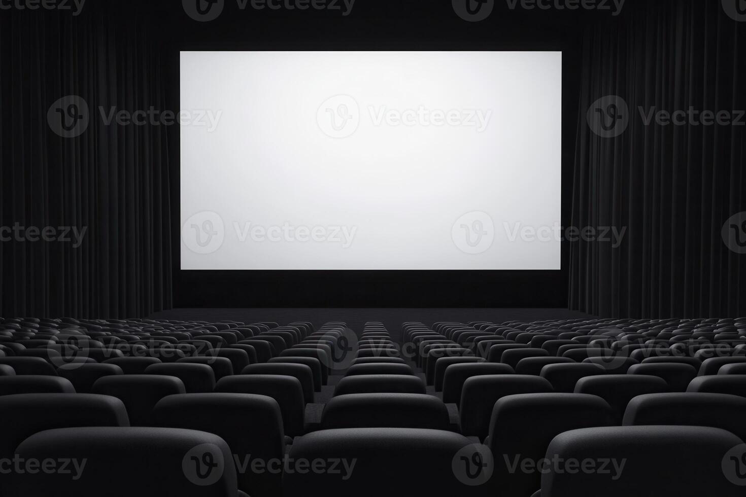 Rows of empty dark seats face a large bright white screen in a spacious viewing theater photo