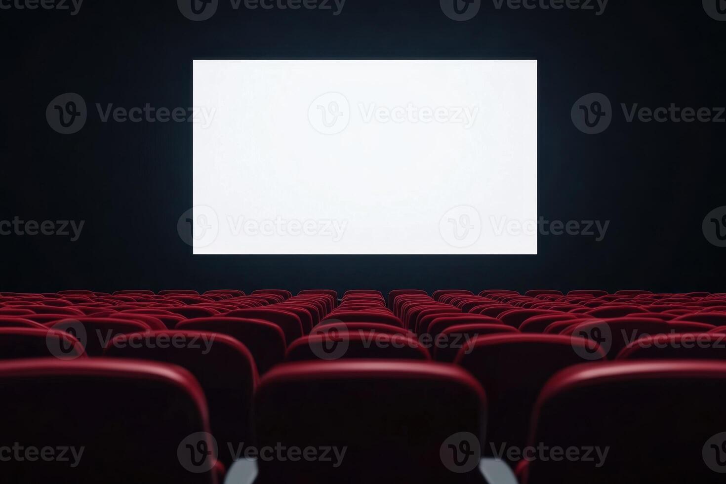 Empty cinema auditorium with rows of red seats facing a blank white screen, awaiting the show photo