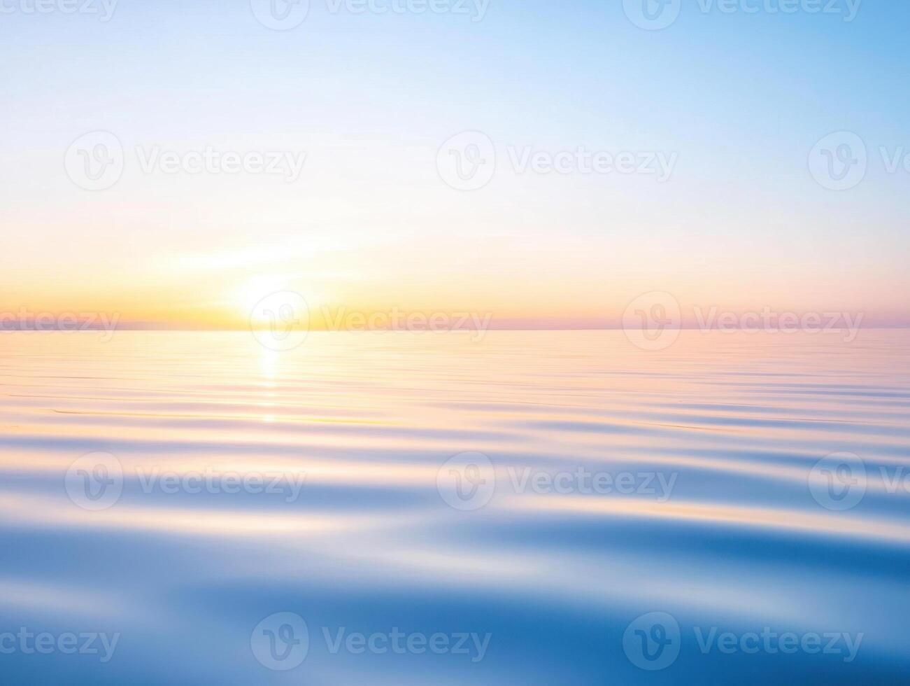 Tranquil ocean sunset reflecting the light of dawn with soft, rippling waves in pale blues photo