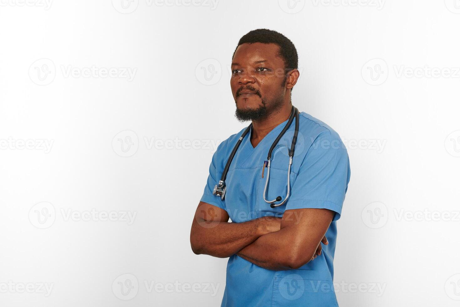 Black surgeon doctor bearded man in blue coat with crossed arms isolated white background copy space photo