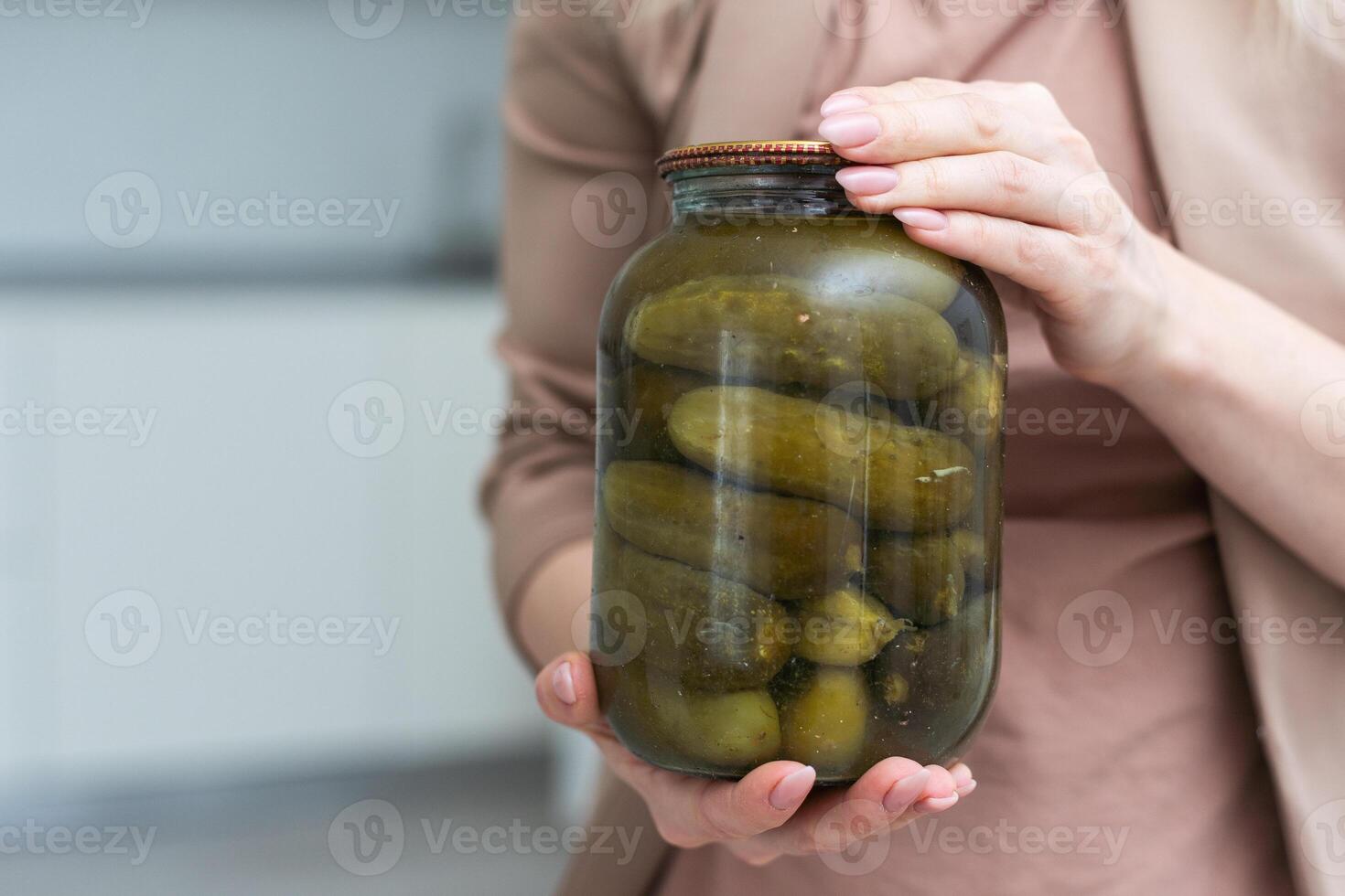 Jar of cucumbers in hand on a white background. Isolation photo