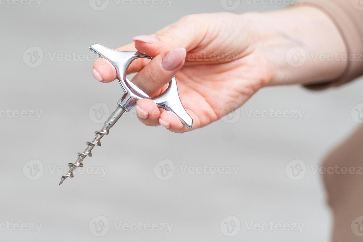 Hand holding corkscrew isolated on white background. Clipping path photo
