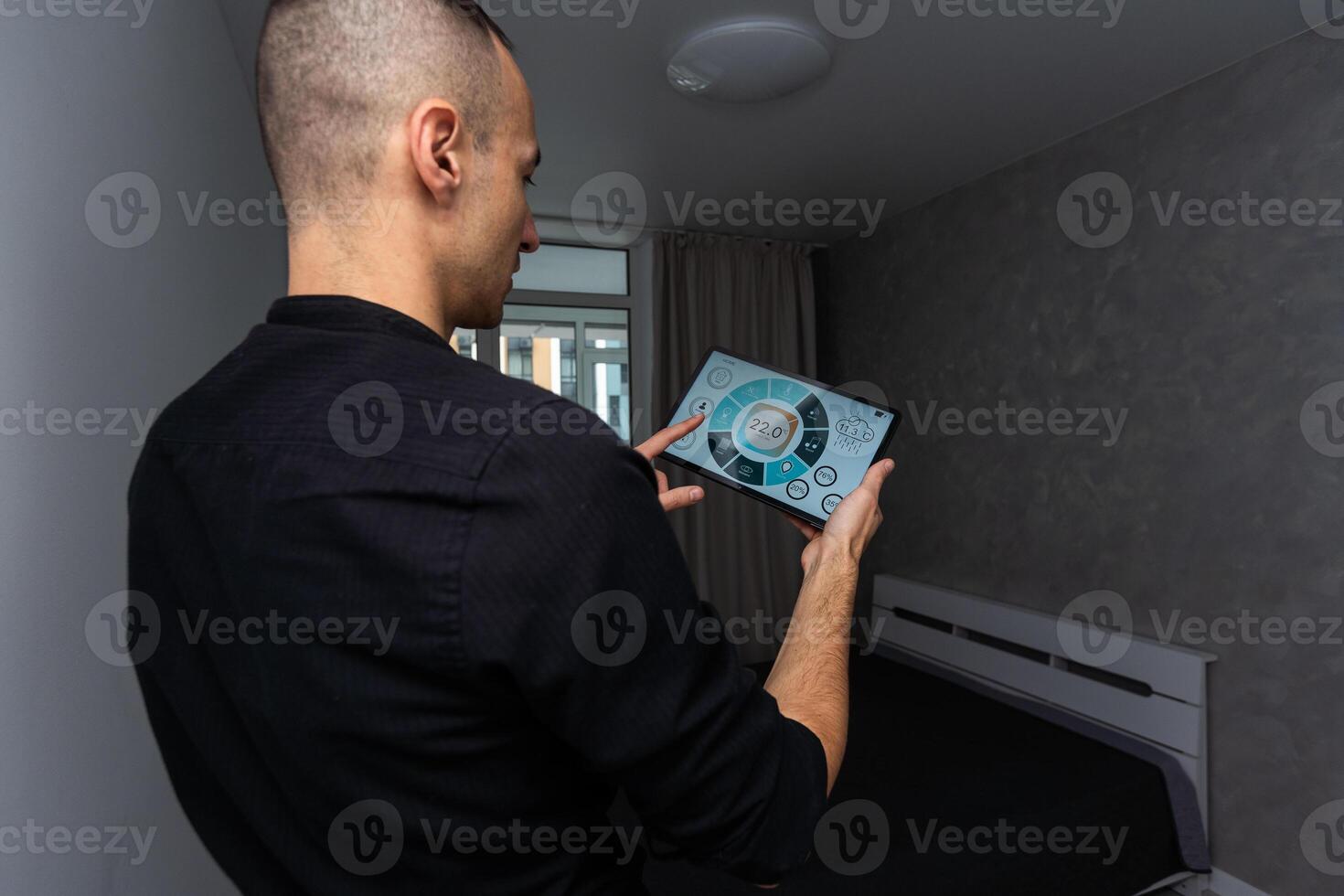 automation, internet of things and technology concept - man looking at tablet pc computer at smart home photo