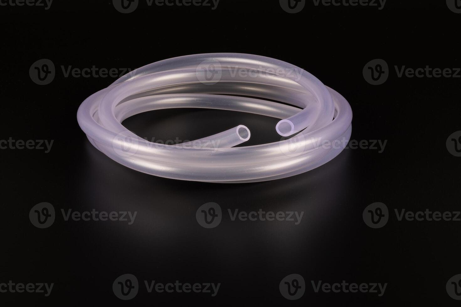 transparent plastic tube coil on black background photo