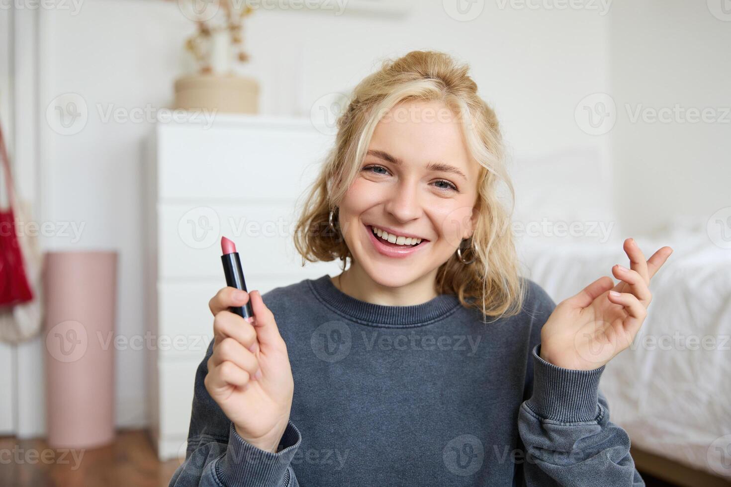 Portrait of young beautiful woman, content maker creating a new vlog, beauty , showing lipstick, recommending makeup, records a tutorial photo