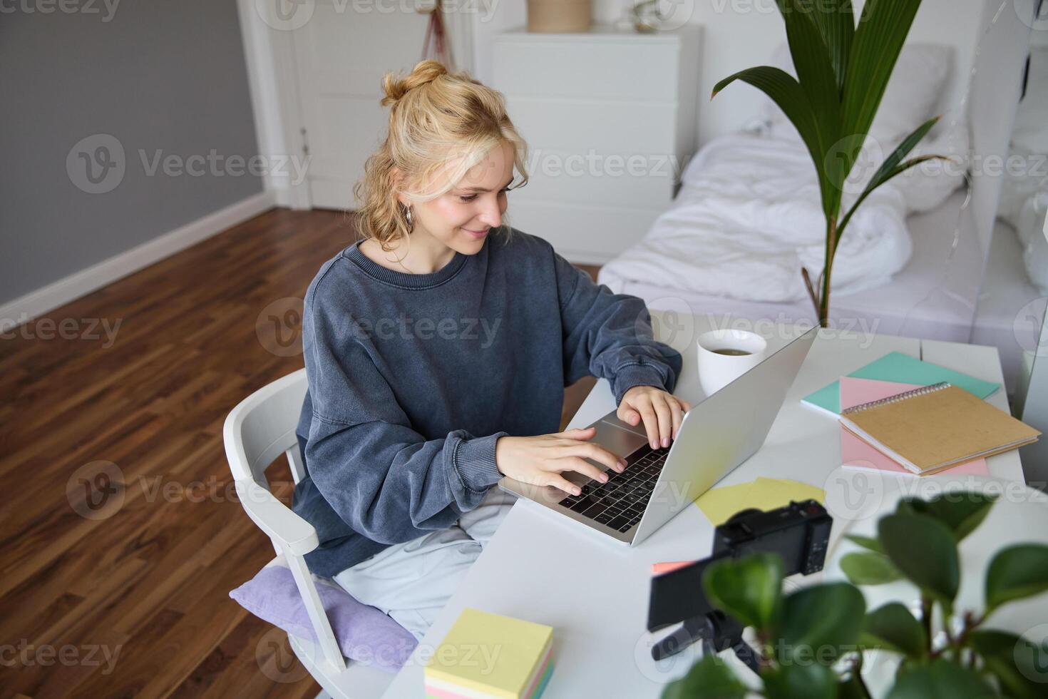 Portrait of young woman distance learning, working from home with laptop, making notes, student studying on remote, doing online course photo