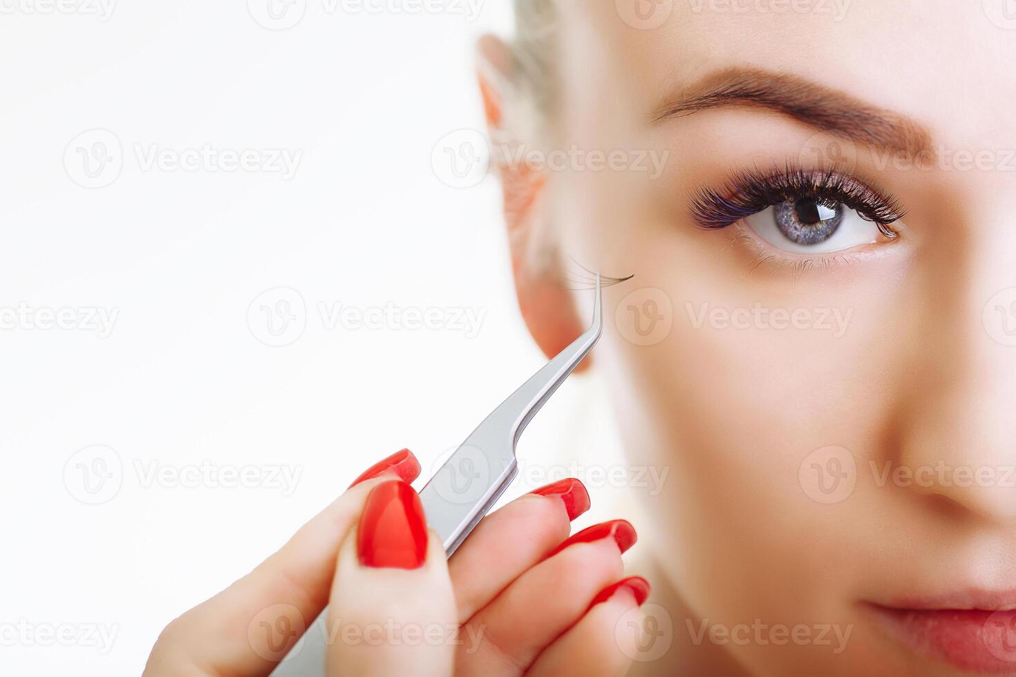 Eyelash Extension Procedure. Woman Eye with Long Eyelashes. Close up, selective focus. photo