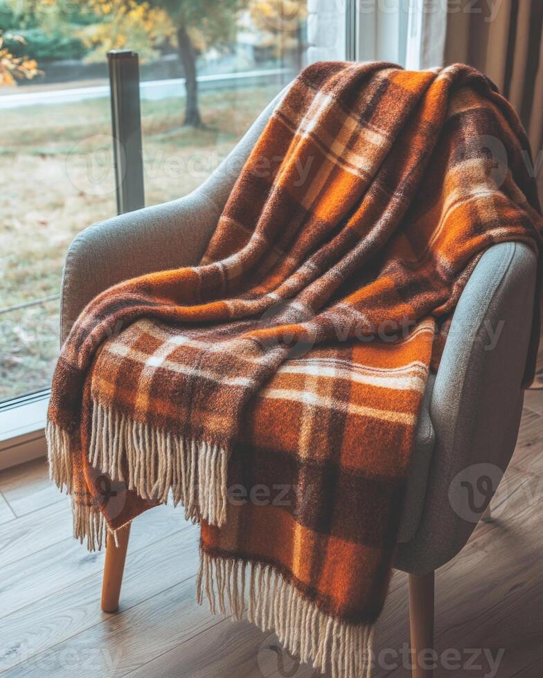 Cozy autumn blanket, plaid pattern, soft wool texture, draped over a chair photo