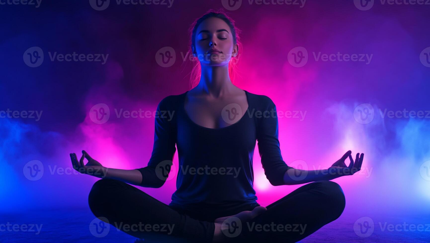 A woman meditating in the lotus position with purple and blue lights photo